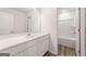 Modern bathroom featuring white cabinets, countertops, a large mirror, and bathtub/shower combo at 8504 Polston Pl # 145, Douglasville, GA 30134