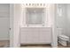 Bright bathroom featuring dual sinks, a large mirror, and a separate toilet area at 8504 Polston Pl # 145, Douglasville, GA 30134