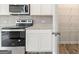 Clean kitchen with stainless steel range, microwave, white cabinets, and granite countertops at 8504 Polston Pl # 145, Douglasville, GA 30134