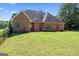 Expansive backyard featuring a brick home, green grass, and mature trees at 1010 Elaine Ct, Mcdonough, GA 30252