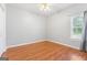 A bright bedroom featuring hardwood floors, a ceiling fan, and a window at 1010 Elaine Ct, Mcdonough, GA 30252