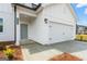Charming home features a clean white exterior, two-car garage and well-manicured front yard at 8502 Polston Place # 144, Douglasville, GA 30134