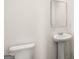 Bathroom featuring white pedestal sink, modern faucet, toilet, and a large mirror at 1949 Van Allen Ct # 4, Dacula, GA 30019