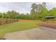 Expansive backyard featuring a well-maintained lawn, wooden fence, concrete patio, and a charming gazebo at 321 Champions Dr, Fairburn, GA 30213