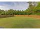 Wide view of the spacious, fenced-in backyard with a well-manicured lawn and mature trees at 321 Champions Dr, Fairburn, GA 30213
