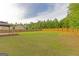 Large, level backyard with a gazebo, enclosed by a wooden privacy fence and mature trees at 321 Champions Dr, Fairburn, GA 30213