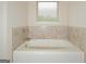 Bathroom featuring a bathtub with tile backsplash and a window at 321 Champions Dr, Fairburn, GA 30213