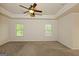Spacious bedroom with carpet floors, a ceiling fan, and two windows providing natural light at 321 Champions Dr, Fairburn, GA 30213