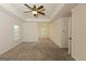 Large bedroom featuring carpet, ceiling fan, and views through two windows at 321 Champions Dr, Fairburn, GA 30213