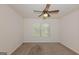 Cozy bedroom with ceiling fan, window, and neutral carpet at 321 Champions Dr, Fairburn, GA 30213