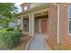Inviting front porch with brick columns and manicured shrubbery at 321 Champions Dr, Fairburn, GA 30213