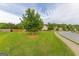 Landscaped front yard featuring a large shade tree and green lawn at 321 Champions Dr, Fairburn, GA 30213