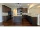 Beautiful kitchen with stainless steel appliances, granite countertops, dark cabinets, and wood floors at 321 Champions Dr, Fairburn, GA 30213