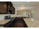 Kitchen with granite counters, dark cabinetry, stainless steel appliances, and hardwood floors at 321 Champions Dr, Fairburn, GA 30213