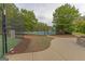 View of fenced community tennis court, surrounded by trees and greenery on a sunny day at 321 Champions Dr, Fairburn, GA 30213
