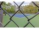 Community tennis court with green and blue surface, viewed through the chain-link fence at 321 Champions Dr, Fairburn, GA 30213