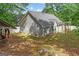 View of home with siding, multiple windows, and a backyard with a covered patio at 556 Walton Dr, Social Circle, GA 30025
