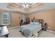 Inviting bedroom with a tray ceiling, ceiling fan, and comfortable bed with plush pillows at 556 Walton Dr, Social Circle, GA 30025