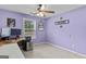 Comfortable bedroom with purple walls, a ceiling fan, carpet flooring, and a window for natural light at 556 Walton Dr, Social Circle, GA 30025