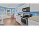 Kitchen with white cabinets, stainless steel appliances, and dining area with a view at 556 Walton Dr, Social Circle, GA 30025