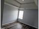 An airy bedroom is displayed, featuring gray walls, hardwood floors, and a bright window at 1762 Wood Stork Drive, Hampton, GA 30228