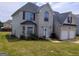 An exterior view of a beautiful two-story home with a well-manicured lawn is displayed at 1762 Wood Stork Drive, Hampton, GA 30228
