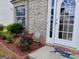 View of front entrance with colorful welcome mat, landscaping, and brick exterior at 1762 Wood Stork Drive, Hampton, GA 30228