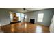 Open living room with fireplace, wood floors, and view of the kitchen at 1762 Wood Stork Drive, Hampton, GA 30228