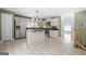 Modern kitchen featuring stainless steel appliances, central island, and a view of the stairwell at 9206 Denmeade Trce, Douglasville, GA 30135