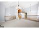 Large open living room with hardwood floors and vaulted ceiling with an adjacent landing and stairwell at 9206 Denmeade Trce, Douglasville, GA 30135
