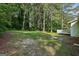 Home's backyard featuring a large lawn and mature trees at 4954 Browns Mill Rd, Lithonia, GA 30038