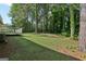Expansive backyard showcasing a lush lawn and mature trees, ideal for outdoor activities and relaxation at 4954 Browns Mill Rd, Lithonia, GA 30038