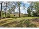 Spacious backyard featuring mature trees, lush lawn, and a charming back deck, perfect for outdoor relaxation at 4954 Browns Mill Rd, Lithonia, GA 30038