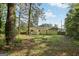 Home's backyard features a large lawn, mature trees and partial fencing at 4954 Browns Mill Rd, Lithonia, GA 30038