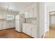 Well-lit kitchen with white cabinetry, appliances, and hardwood floors, creating a clean and functional space at 4954 Browns Mill Rd, Lithonia, GA 30038