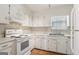 Functional kitchen featuring white appliances, cabinetry, and hardwood floors, offering ample counter space at 4954 Browns Mill Rd, Lithonia, GA 30038