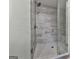 Luxurious shower with glass door, marble walls, and hexagon-tiled floor at 1020 Broadview Dr, Marietta, GA 30062