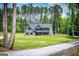 Wide view of the blue two-story home featuring a large lawn and tree-lined property at 457 Paynes Lake Rd, Carrollton, GA 30116