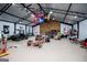 Spacious garage with high ceilings, ceiling fan, flags, and work area for car repairs and maintenance at 457 Paynes Lake Rd, Carrollton, GA 30116