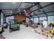 Open garage with a high ceiling and exposed rafters, containing automotive equipment and repair projects at 457 Paynes Lake Rd, Carrollton, GA 30116