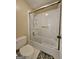 Bathroom featuring a shower-tub combo, bright white tile, and a large glass door at 110 Vicarage Ct, Johns Creek, GA 30005