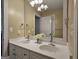 Bathroom featuring dual sinks, a large mirror, decorative lighting, and soft neutral tones at 110 Vicarage Ct, Johns Creek, GA 30005