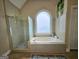 Bathroom featuring walk-in shower, soaker tub, and large arched window at 110 Vicarage Ct, Johns Creek, GA 30005
