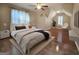 Inviting bedroom featuring hardwood floors, ceiling fan, soft decor, and bright natural light at 110 Vicarage Ct, Johns Creek, GA 30005