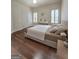 This bedroom offers hardwood floors, soft decor, and bright natural light from the shuttered windows at 110 Vicarage Ct, Johns Creek, GA 30005