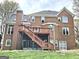 Back exterior view of brick home featuring multi-level deck, screened-in porch, and ample natural light at 110 Vicarage Ct, Johns Creek, GA 30005