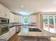 Well-lit kitchen with granite counters, an island with cooktop, and stainless steel appliances at 110 Vicarage Ct, Johns Creek, GA 30005