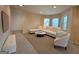 Open-concept living room featuring a large neutral sectional sofa, white furniture, and bright natural light at 110 Vicarage Ct, Johns Creek, GA 30005