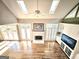 Bright living room with vaulted ceilings, fireplace, custom built-ins, and hardwood flooring at 110 Vicarage Ct, Johns Creek, GA 30005