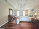 Bedroom featuring hardwood floors, a tray ceiling with a ceiling fan, and a comfortable bed with lamps at 110 Vicarage Ct, Johns Creek, GA 30005